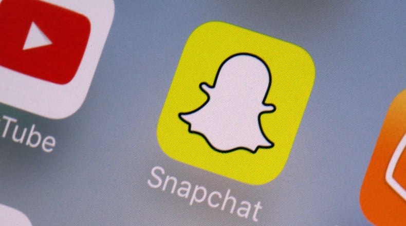 FILE- This Aug. 9, 2017, file photo shows the Youtube, left, and Snapchat apps on a mobile device in New York. (AP Photo/Richard Drew, File)