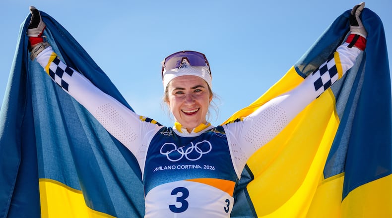 Ebba Andersson, of Sweden, celebrates after winning the gold medal in the cross country skiing women's 50km mass start classic at the 2026 Winter Olympics, in Tesero, Italy, Sunday, Feb. 22, 2026. (AP Photo/Matthias Schrader)