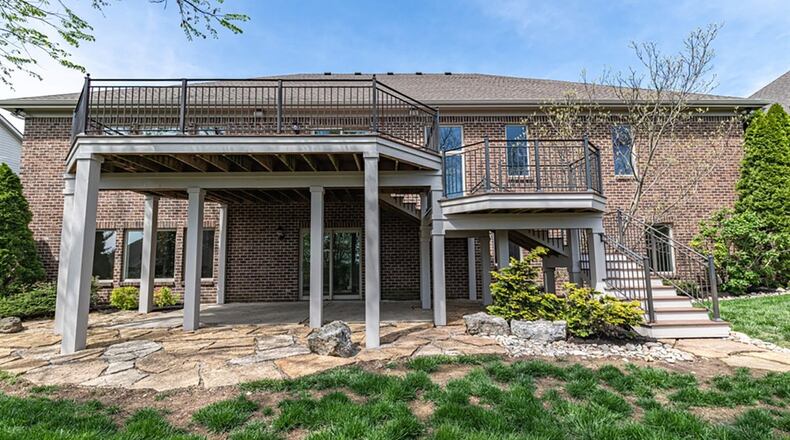Sliding patio doors open to a multi-level balcony rear deck and fenced back yard.