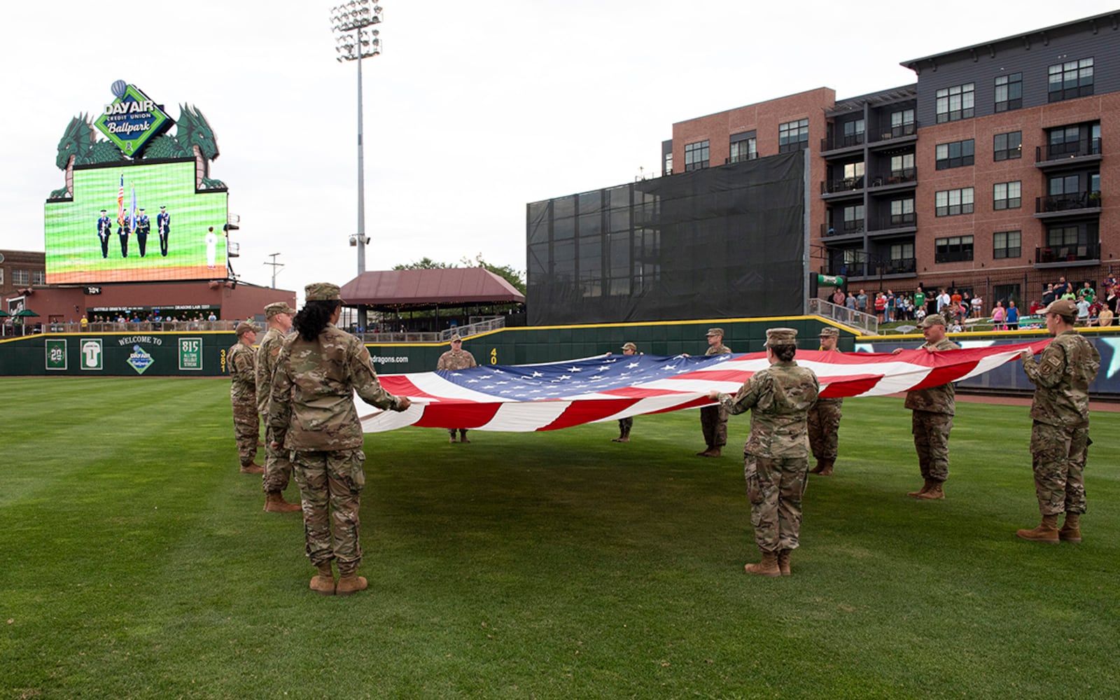 Airmen from Wright-Patterson Air Force Base display a large American flag during Day Air Ballpark’s American Celebration night Aug. 13. The annual Dayton Dragons tribute included military static displays, posting of the colors by WPAFB’s Honor Guard, and the swearing-in of new Air Force and Marine recruits. U.S. AIR FORCE PHOTO/JAIMA FOGG