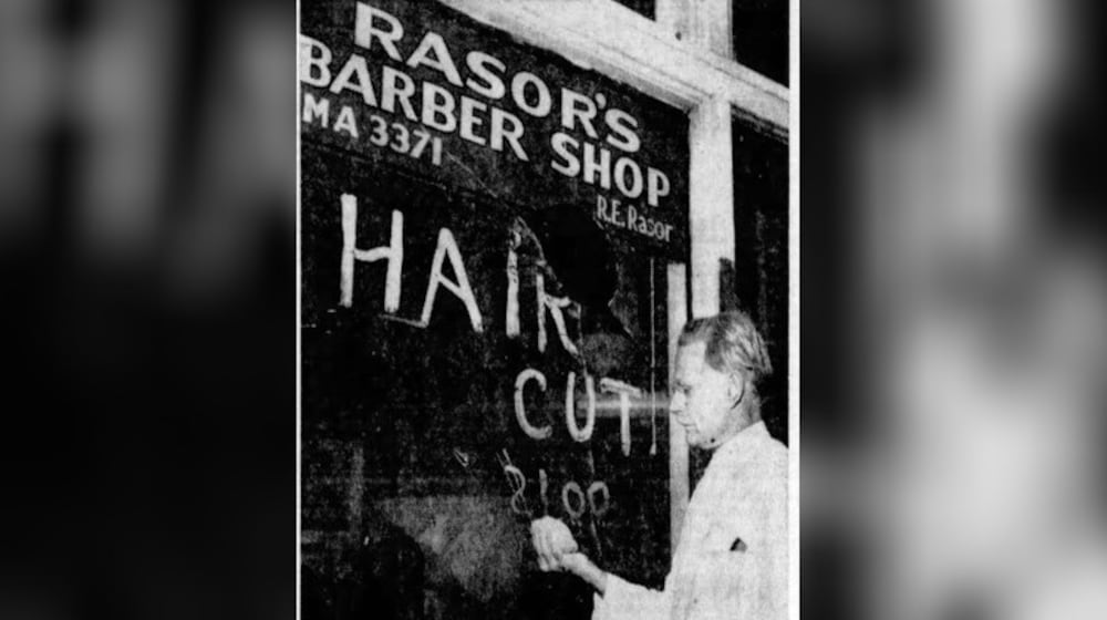 R. E. Rasor, owner of a barber shop at 610 Wilfred Ave. is holding the rock which crashed through his plate glass window. Rasor thinks some other barbers are trying to "pressure" his haircut prices up. DAYTON DAILY NEWS ARCHIVES 1950.