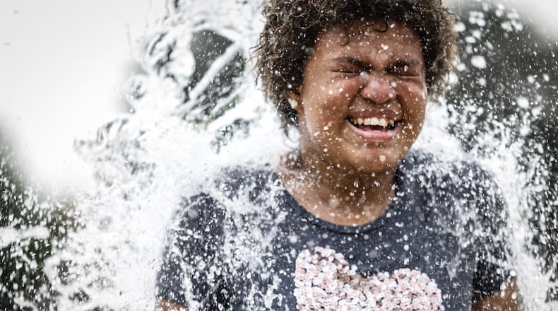 Frost Anderson, from Dayton, enjoys the splash pad at W.S. Mcintosh Park in Dayton. Temperatures are expected to reach the 90s this week. JIM NOELKER/STAFF