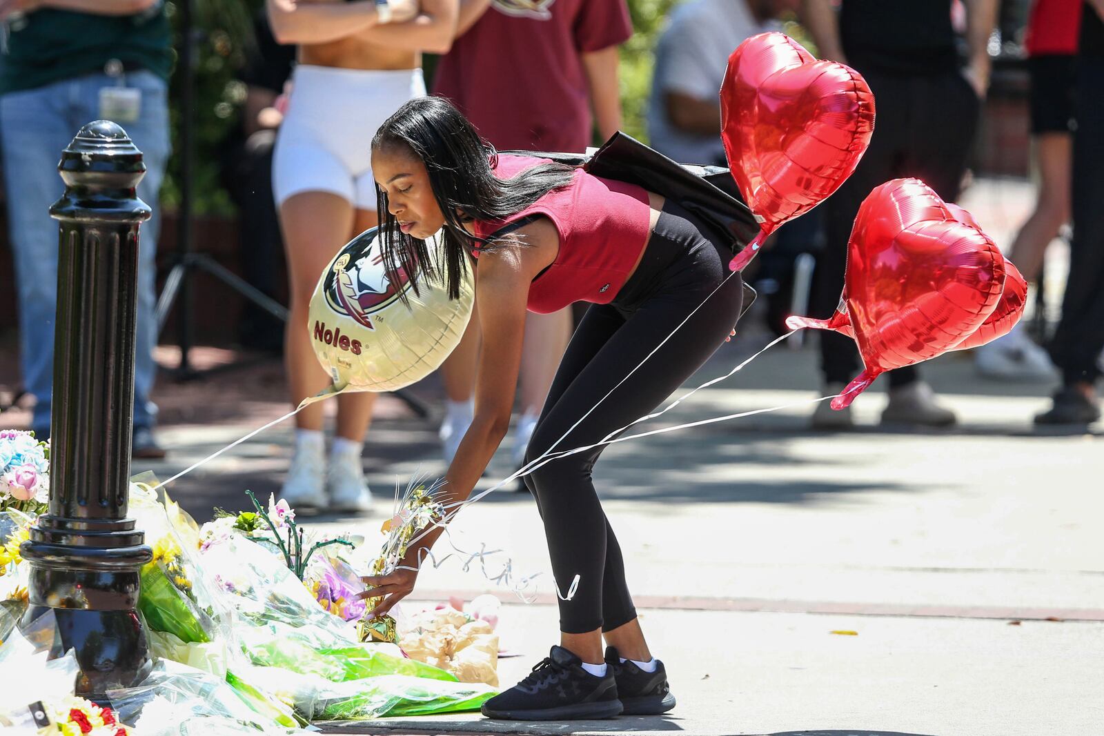A student places heart-shaped balloons near the Florida State Student Union building, Tallahassee, Fla., Friday, April 18, 2025. (AP Photo/Gary McCullough)