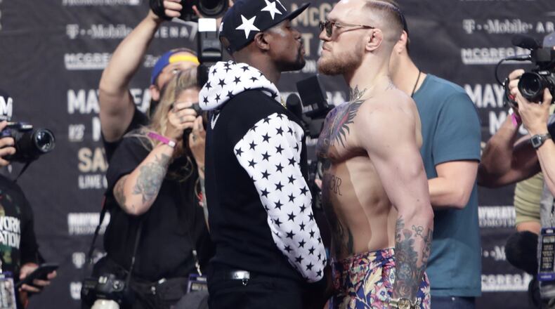 This July 13, 2017 photo shows Floyd Mayweather Jr., left, and Conor McGregor, of Ireland, facing each other for photos during a news conference at Barclays Center in New York. So far fans aren't exactly storming the box office to buy tickets for Mayweather Jr.'s fight next month with McGregor. A check online Saturday, July 29, 2017 revealed hundreds _ even thousands _ of seats still available from Ticketmaster at the T-Mobile arena for the Aug. 26 fight. There are so many open seats that fans with enough room left on their credit cards can buy six tickets together in 162 different spots throughout the arena. (AP Photo/Frank Franklin II)