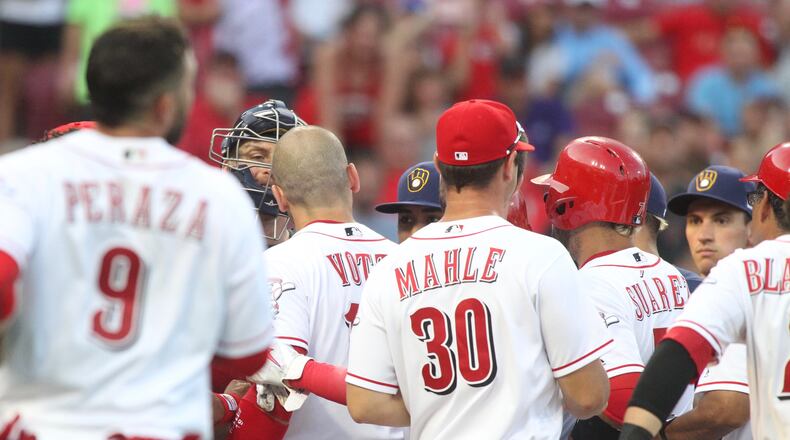The Reds’ Joey Votto and Brewers catcher Erik Kratz exchange words at home plate in the third inning on Thursday, June 28, 2018, at Great American Ball Park in Cincinnati. David Jablonski/Staff