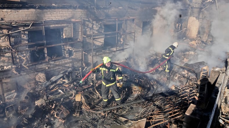 Firefighters put out the fire at a residential neighbourhood following a Russia missile and drone attack, in Brovary, close to Kyiv, Ukraine, Saturday, March 14, 2026. (AP Photo/Efrem Lukatsky)