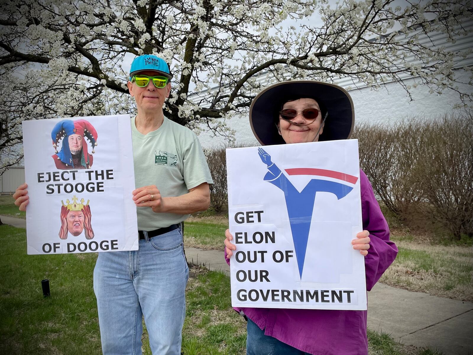 A crowd of more than 100 people lined both sides of West Dorothy Lane in front of the Tesla Service Center in Moraine on Saturday, March 29 as part of a nationwide “Tesla Takedown” movement. Pictured (right) is Mary Combs of Dayton. NATALIE JONES/STAFF