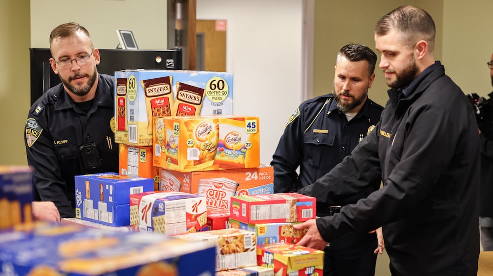 From left to right, Wright State police captain Stefan Kempf, chief of police Kurt Holden and sergeant Nick Quillen unload food donations in the Raider Food Pantry in the university's Student Union on Tuesday, Nov. 24. Wright State's police department raised about $2,000 through a "No Shave November," effort to purchase food for the university's food pantry. BRYANT BILLING/STAFF
