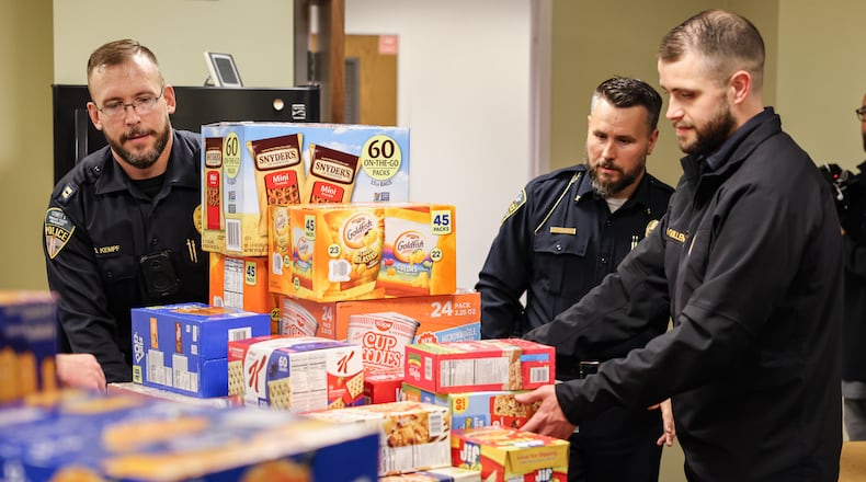 From left to right, Wright State police captain Stefan Kempf, chief of police Kurt Holden and sergeant Nick Quillen unload food donations in the Raider Food Pantry in the university's Student Union on Tuesday, Nov. 24. Wright State's police department raised about $2,000 through a "No Shave November," effort to purchase food for the university's food pantry. BRYANT BILLING/STAFF