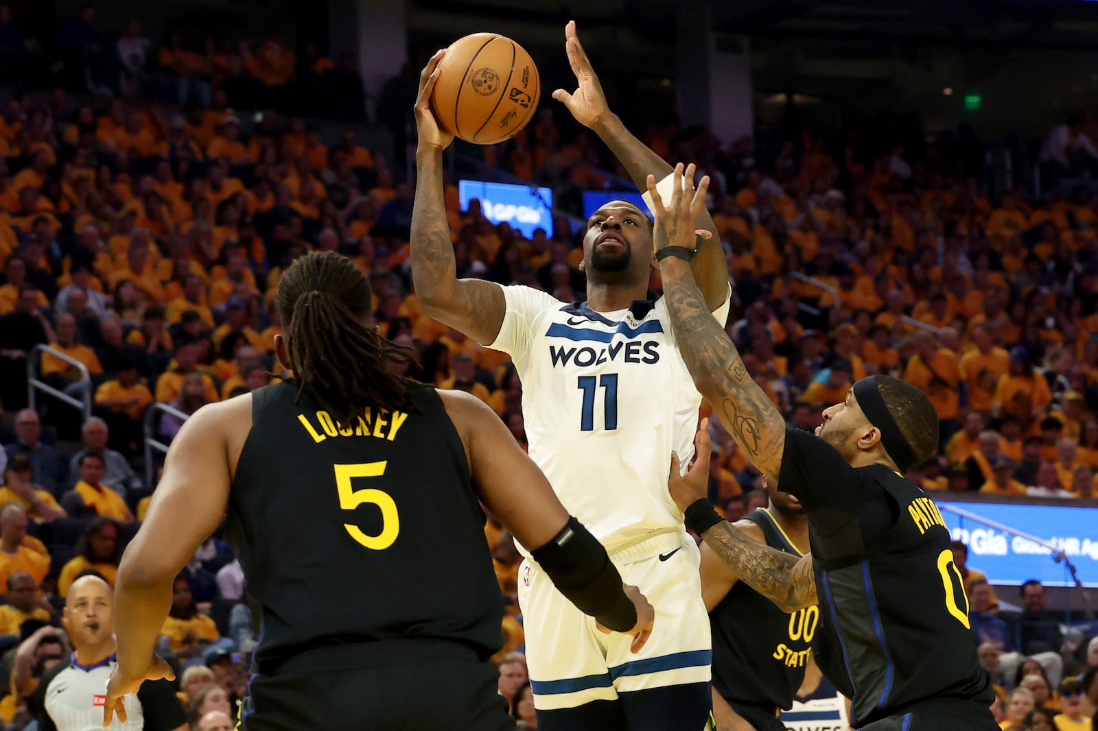 Minnesota Timberwolves center Naz Reid (11) shoots against Golden State Warriors guard Gary Payton II (0) and forward Kevon Looney (5) during the first half of Game 4 in the Western Conference semifinals of the NBA basketball playoffs Monday, May 12, 2025, in San Francisco. (AP Photo/Jed Jacobsohn)