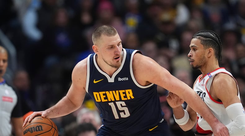 Denver Nuggets center Nikola Jokic, left, drives to the basket as Portland Trail Blazers forward Toumani Camara defends in the second half of an NBA basketball game Wednesday, Feb. 12, 2025, in Denver. (AP Photo/David Zalubowski)