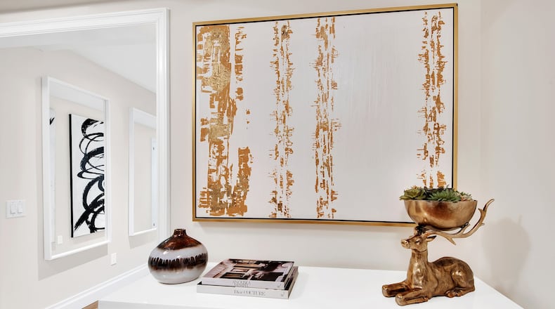 Gold artwork paired with a gold accent piece helps make this entry area shine. (Design Recipes)