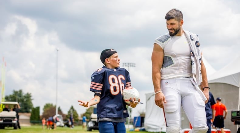 Chicago Bears tight end Zach Miller, right, and 9-year-old Ryan Cremeens walk off a practice field during the Bears' training camp at Olivet Nazarene University in Bourbonnais, Ill., on August 2, 2017. (Armando L. Sanchez/Chicago Tribune/TNS)