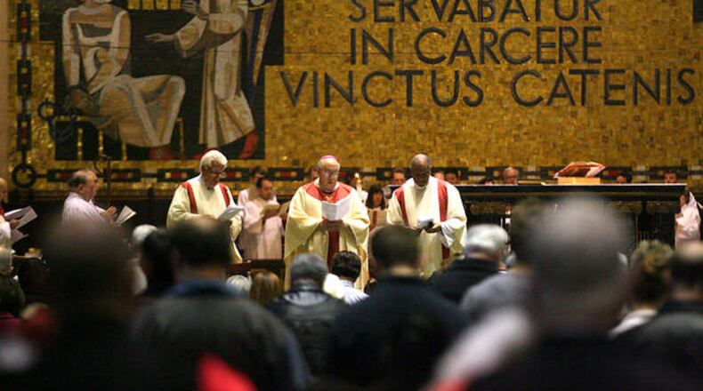 A Roman Catholic Mass is celebrated at St. Peter in Chains Cathedral in downtown Cincinnati to celebrate the election of Pope Francis in a 2013 file photo. Behind the altar, a mosaic in Latin says “Et Petrus quidem servabatur in carcere vinctus catenis,” which translates, “And Peter was kept in prison, bound in chains.” KAREEM ELGAZZAR / WCPO-TV