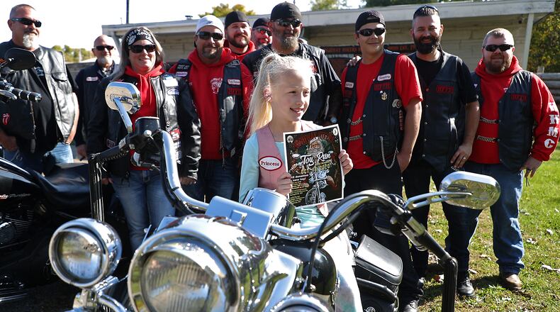 The youngest member of the Highway Hikers Motorcycle Club, Laila Vose, 8, holds a poster for the Highway Hikers Motorcycle Club's 2020 Toy Run, which takes place on October 18. BILL LACKEY/STAFF