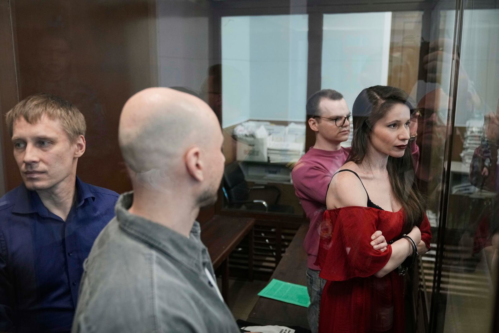 Russian journalists, from left, Konstantin Gabov, Sergey Karelin, Artyom Kriger and Antonina Favorskaya, accused of working for a group founded by the late Russian opposition politician Alexei Navalny, stand in a defendant's cage of the Nagatinsky District Court in Moscow, Russia, Tuesday, April 15, 2025. (AP Photo)