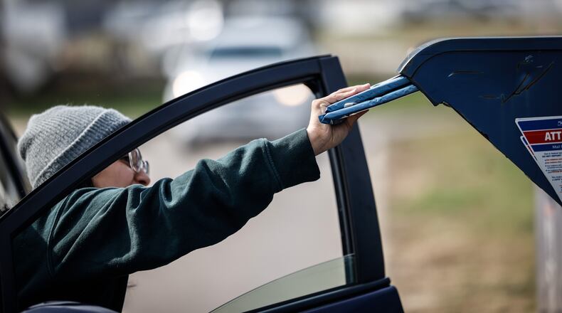A driver drops mail off at the drop boxes in front of the Stroop Road Post Office in Kettering on Wednesday March 30, 2022. Four men, one from Dayton, were recently charged with a string of check thefts from U.S. Postal Service mailboxes in Kettering. JIM NOELKER/STAFF