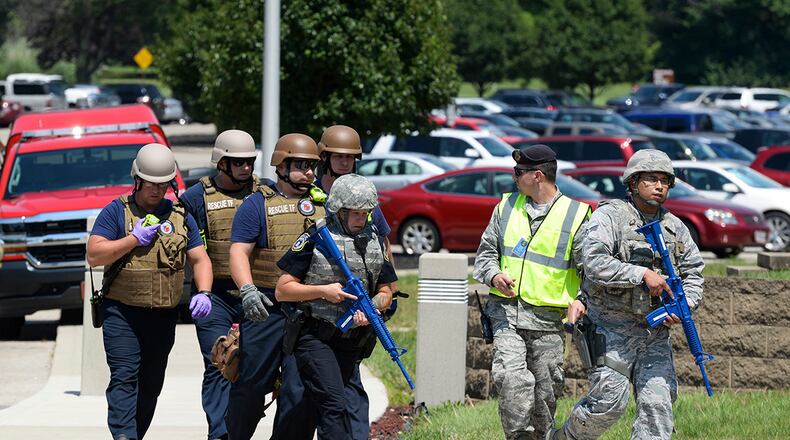 Members of the 788th Security Forces Squadron escort medical personnel with the 88th Civil Engineer Squadron Fire Department into the National Air and Space Intelligence Center to aid “casualties” during an August 2017 exercise. Military installations are required to conduct active-shooter exercises twice a year. U.S. AIR FORCE PHOTO/WESLEY FARNSWORTH