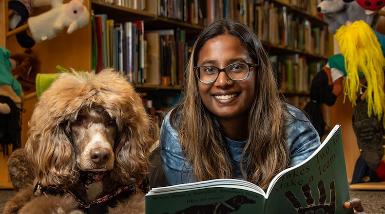 Anjali Edwards, who graduated in 2022 from Wright State with a bachelor’s degree in psychology, with her service dog, Teddy, one of the dogs featured in her new book, “It Takes Two to Make a Team: How Service Animals Can Change the Lives of their Handlers.” Contributed