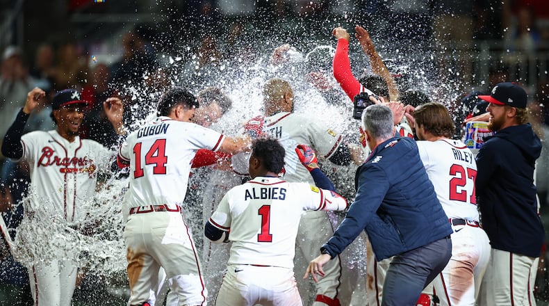 The Atlanta Braves celebrate at home plate after a walkoff grand slam from Dominic Smith, center, in the ninth inning of a baseball game against the Kansas City Royals, Saturday, March 28, 2026, in Atlanta. (AP Photo/Colin Hubbard)