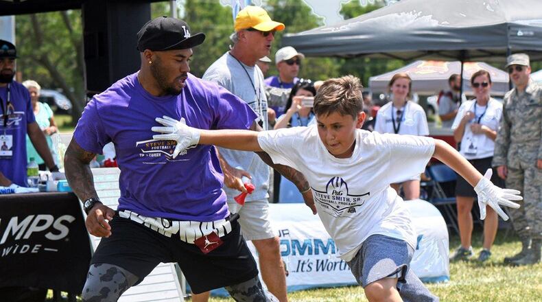 Steve Smith, former National Football League all-pro wide receiver with the Baltimore Ravens and Carolina Panthers football teams, instructs a young receiver on running a correct pass route during the NFL Football ProCamp clinic at Wright-Patterson Air Force Base July 9. The clinic, sponsored by the Defense Commissary Agency, was a 2-day event open to boys and girls in grades 1-8, who are dependents of active-duty, retirees and Department of Defense civilian employees. (U.S. Air Force photo/Al Bright)