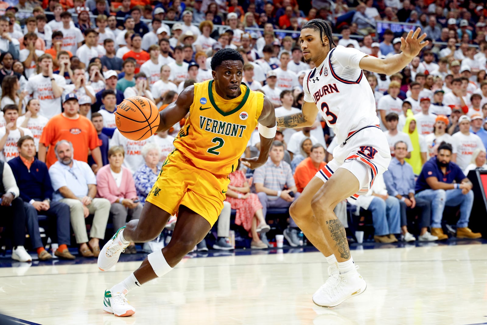 Vermont guard Sam Alamutu (2) drives the baseline around Auburn forward Jahki Howard (3) during the first half of an NCAA college basketball game, Wednesday, Nov. 6, 2024, in Auburn, Ala. (AP Photo/ Butch Dill)