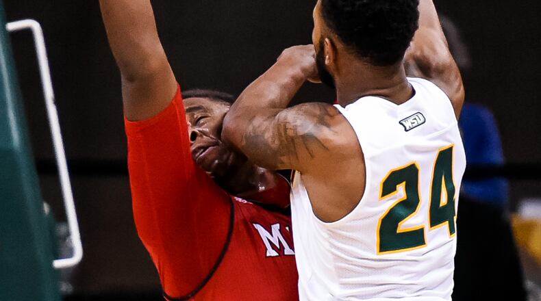 Wright State University’s Mark Alstork lands an elbow to the face of Miami University’s Darius Harper as he takes a shot during their 89-87 win Miami Tuesday, Nov. 15 at Wright State University’s Nutter Center in Fairborn. NICK GRAHAM/STAFF