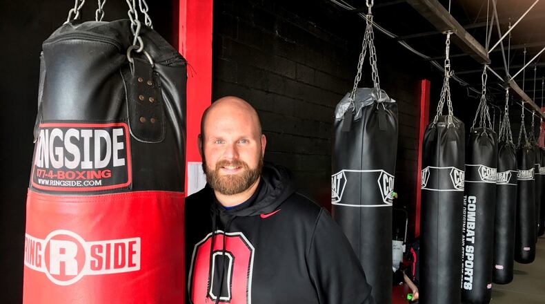 Will Ashcraft holding a heavy bag in M-Power Gym. Tom Archdeacon/CONTRIBUTED