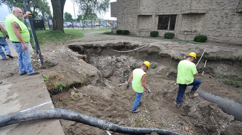 Dayton Street crews work to repair a large watermain break along Keowee Street Tuesday. MARSHALL GORBY\STAFF