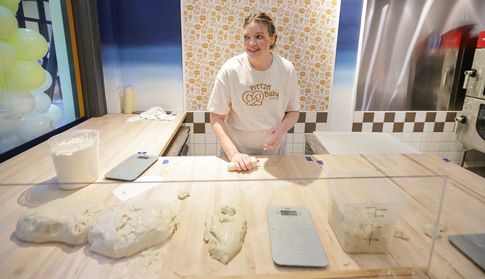 Emma Smales, a fifth-generation owner of Smales Pretzel Bakery, rolls dough in the business' location in the north section of the Dayton Arcade on Friday, March 6.  The Dayton Arcade celebrated the opening of the north section on Friday, March 6 with a Friends and Family Retail Reveal event. BRYANT BILLING / STAFF