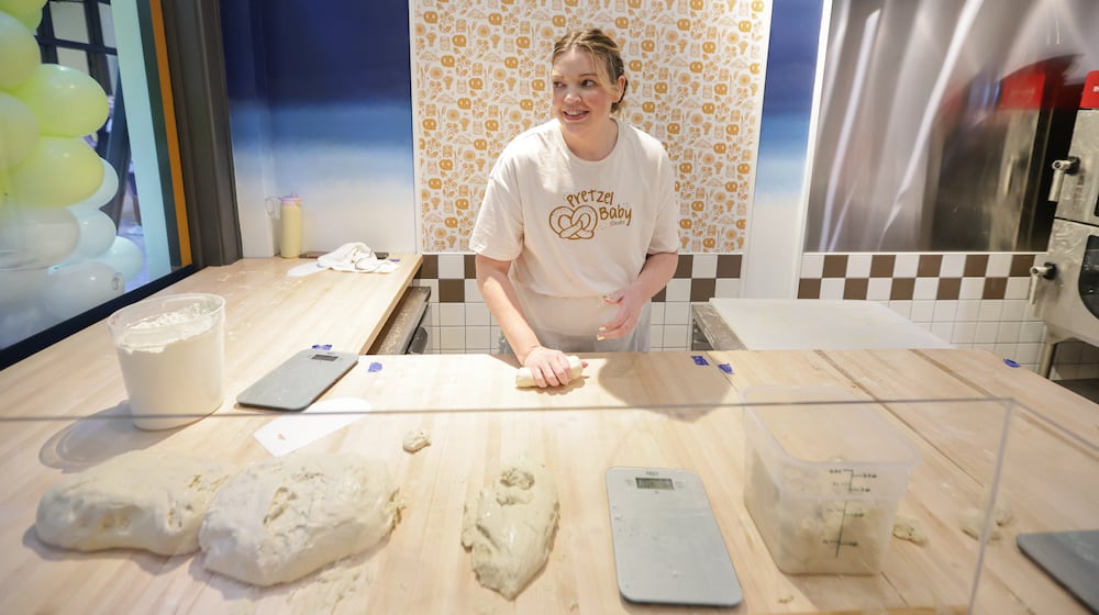 Emma Smales, a fifth-generation owner of Smales Pretzel Bakery, rolls dough in the business' location in the north section of the Dayton Arcade on Friday, March 6. The Dayton Arcade celebrated the opening of the north section on Friday, March 6 with a Friends and Family Retail Reveal event. BRYANT BILLING/STAFF