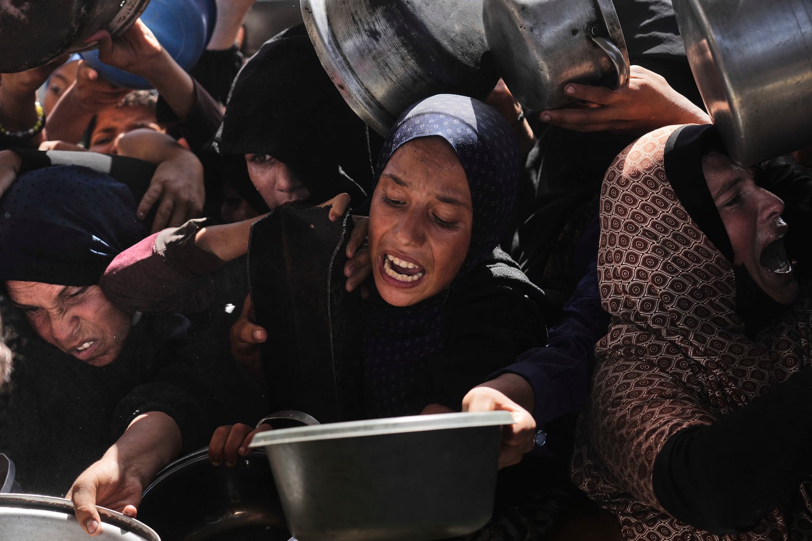 Palestinians struggle to obtain donated food at a community kitchen in Khan Younis, in the southern Gaza Strip, Friday, May 9, 2025. (AP Photo/Abdel Kareem Hana)