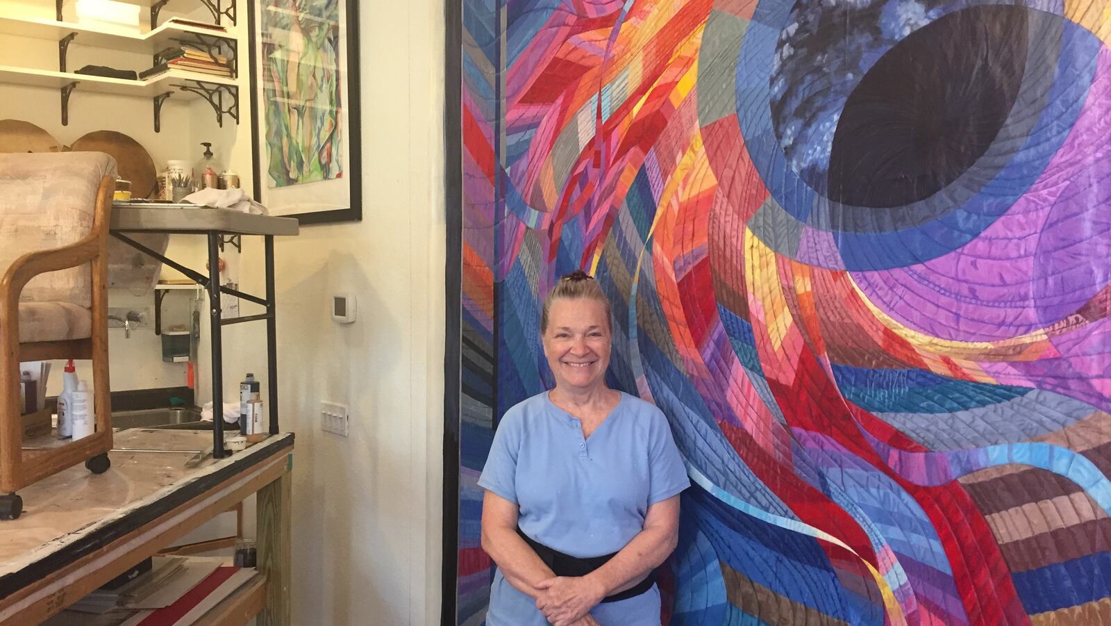 Artist Char Downs, who moved to Paducah from the San Francisco area as part of the city's artist relocation program, stands in her studio by her painting of Caryl Bryer Fallert-Gentry's quilt titled Corona II: Solar Eclipse. (Lori Rackl/Chicago Tribune/TNS)