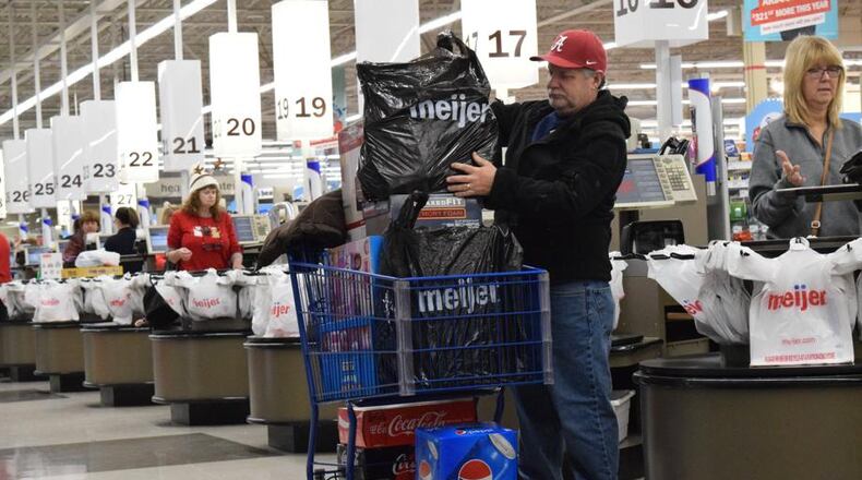 A shopper loads groceries into a shopping cart at the Meijer location in Miami Twp. Meijer is working to bring new restaurants and other businesses to outlots in front of their stores throughout the region, including locations in Miami Twp., Kettering, Huber Heights and Beavercreek.