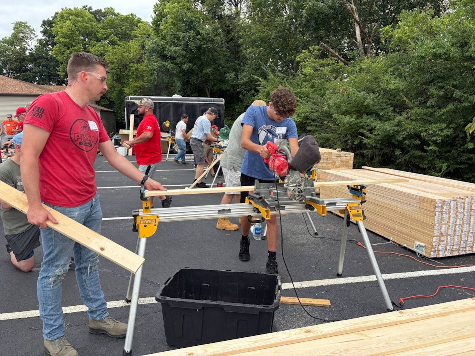 Volunteer Jackson Spitler saws planks for bed frames at Fairhaven Church's Family Serve Day on Saturday, Aug. 23, 2025. To Spitler's right is fellow volunteer Seth Taylor, guiding the wood. THOMAS GNAU/STAFF