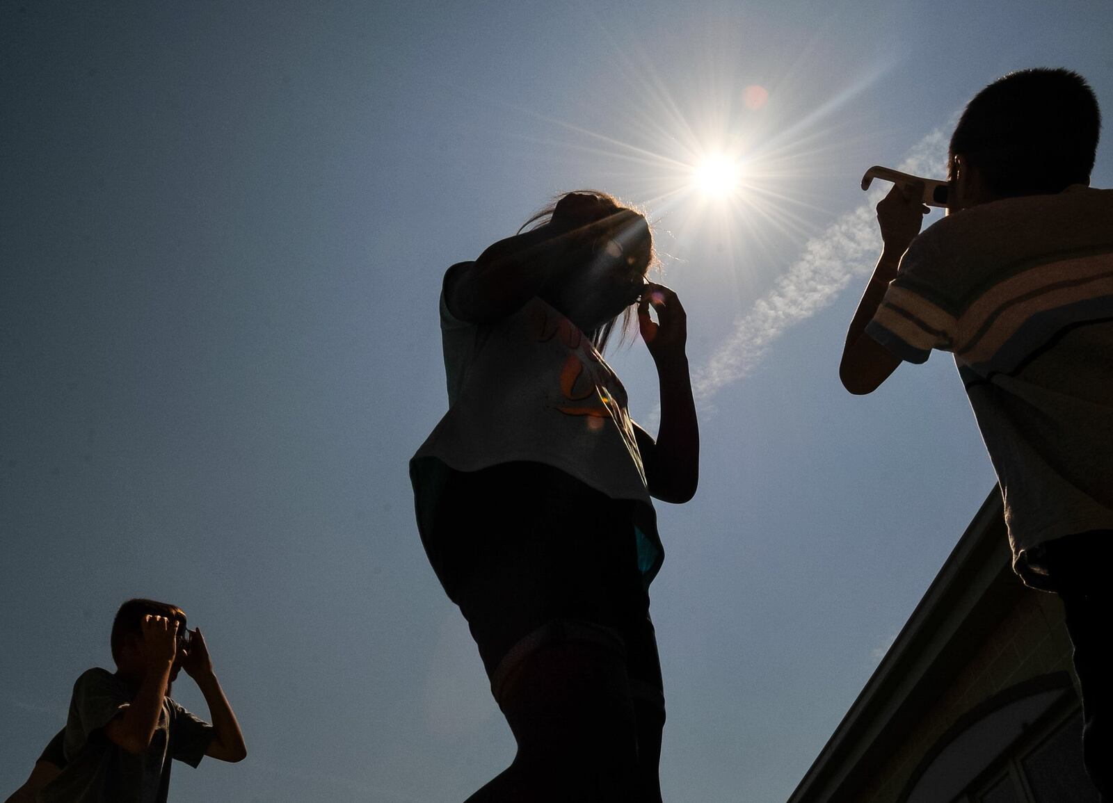 Students at Lakota’s Endeavor Elementary spend some time outside viewing the solar eclipse through approved solar glasses Monday, Aug. 21 in West Chester Township. NICK GRAHAM/STAFF
