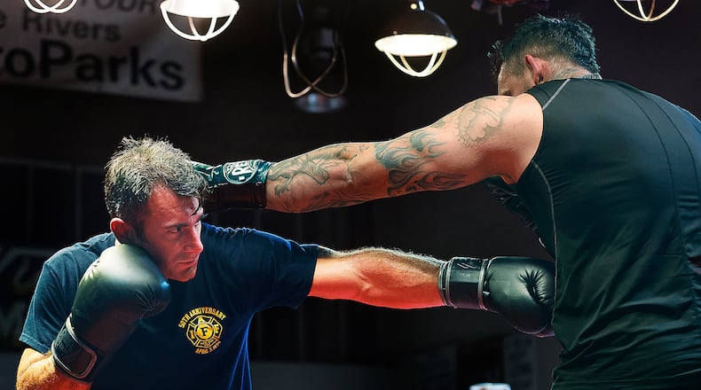 Xenia firefighter Warren Roberds, left, trains at Drake's Downtown Gym in Dayton ahead of the Dawg Fight charity exhibition tournament next Thursday. MARSHALL GORBY\STAFF