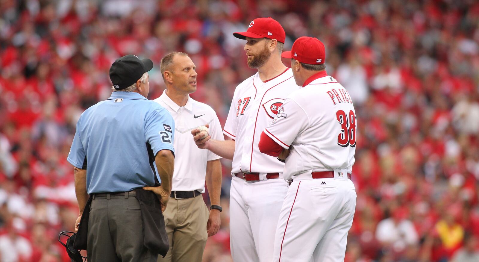 Reds starter Scott Feldman talks to a trainer and manager Bryan Price, right, during a game against the Phillies on Monday, April 3, 2017, at Great American Ball Park in Cincinnati. David Jablonski/Staff