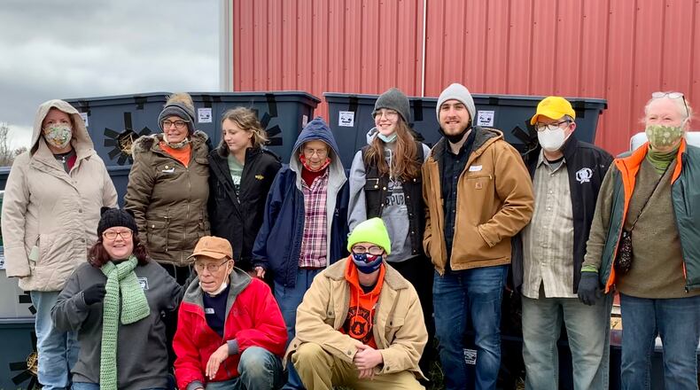 Chris Banks (bottom left) and volunteers with the Dayton Community Cat Project in front of over 20 cat shelters built on Nov. 13. LONDON BISHOP/STAFF
