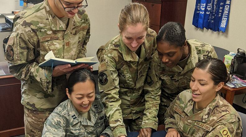 Air University Squadron Officer School students Capt. James Flores-Lombay, Capt. Jessica Sunkamaneevongse, Capt. Kristen Ricker, Capt. Tanisha Bramwell-Boose and Air Force Office of Special Investigations Special Agent Alexandra Garced discuss a redesign of the maternity service dress uniform Feb. 26 at Air University, Maxwell Air Force Base, Ala. The students signed up to take the Air University Advanced Research elective to research a redesign of the maternity service dress uniform. (U.S. Air Force courtesy photo)