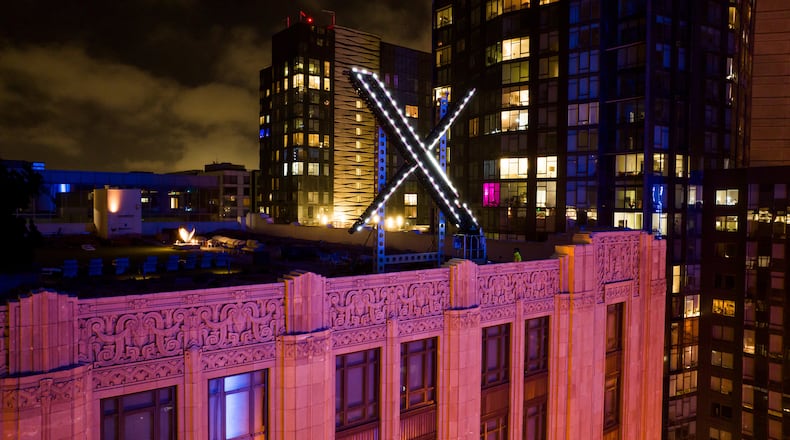 FILE - Workers install lighting on an "X" sign atop the company headquarters, formerly known as Twitter, in downtown San Francisco, July 28, 2023. (AP Photo/Noah Berger, File)