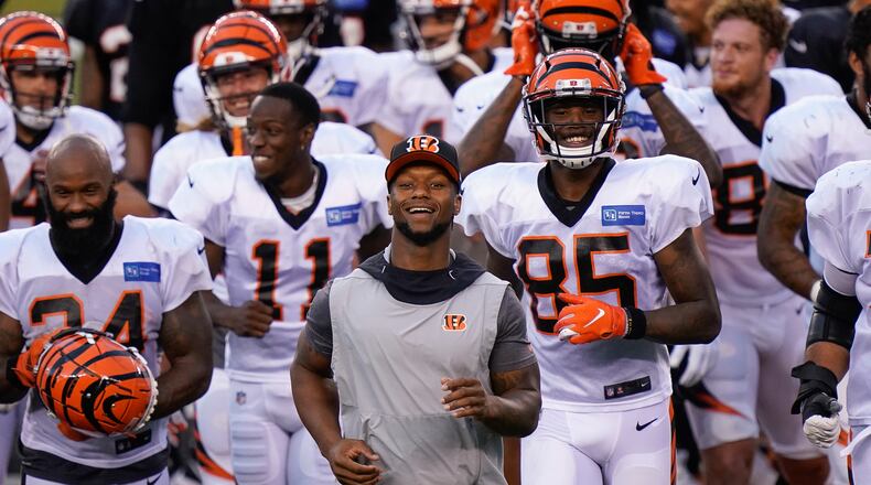 Cincinnati Bengals running back Joe Mixon (28) (center), who didn't dress for play, runs off the field after an NFL football team scrimmage in Cincinnati, Sunday, Aug. 30, 2020. (AP Photo/Bryan Woolston)