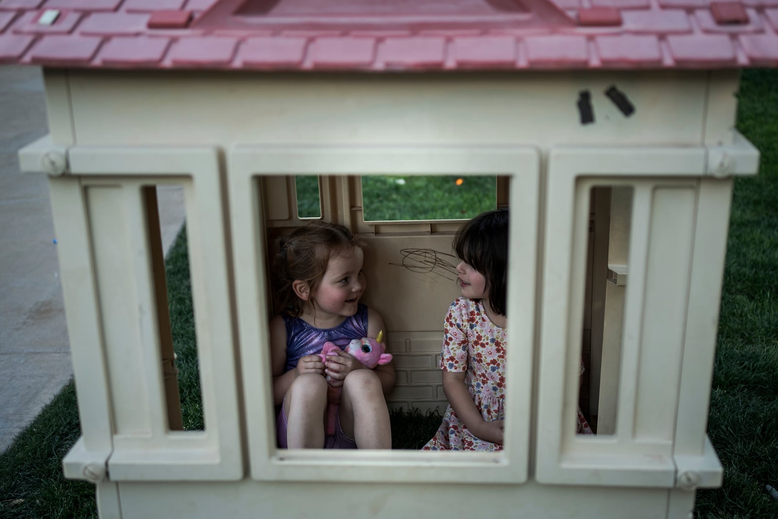Josie, 3, and Fae Padron, 4, play house in a "kid pod," a cluster of families with more than 20 kids between them, at Agritopia, a community nestled around a plot of agricultural land, April 21, 2025, in Gilbert, Ariz. (AP Photo/Annika Hammerschlag)