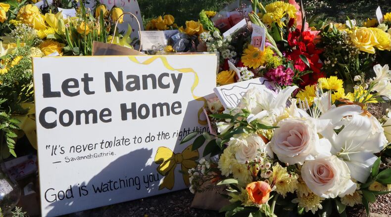 A memorial grows outside the home of Nancy Guthrie, the missing mother of "Today" show host Savannah Guthrie, on Sunday, Feb. 22, 2026, in Tucson, Ariz. (AP Photo/Felicia Fonseca)