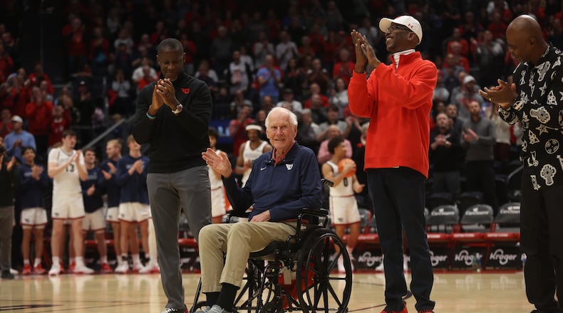 Dayton's all-time winningest coach, Don Donoher, center, is honored at halftime of a game against Grambling State on Saturday, Dec. 2, 2023, at UD Arena. Dayton's current coach Anthony Grant, left, and Roosevelt Chapman, right, were honored along with other members of Dayton's 1984 Elite Eight team. David Jablonski/Staff