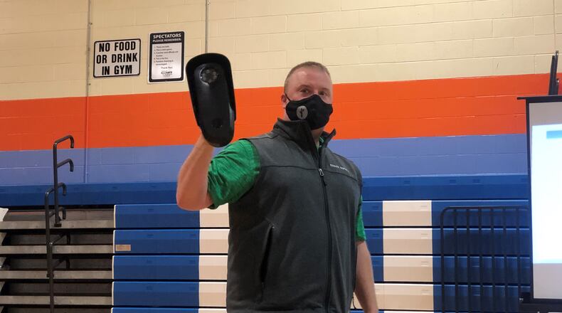 Flock Safety Territory Manager Rick Lombardo holds an automated license plate reader at a recent community meeting. The Dayton Police Department says it is considering deploying the devices in neighborhoods that want them. CORNELIUS FROLIK / STAFF