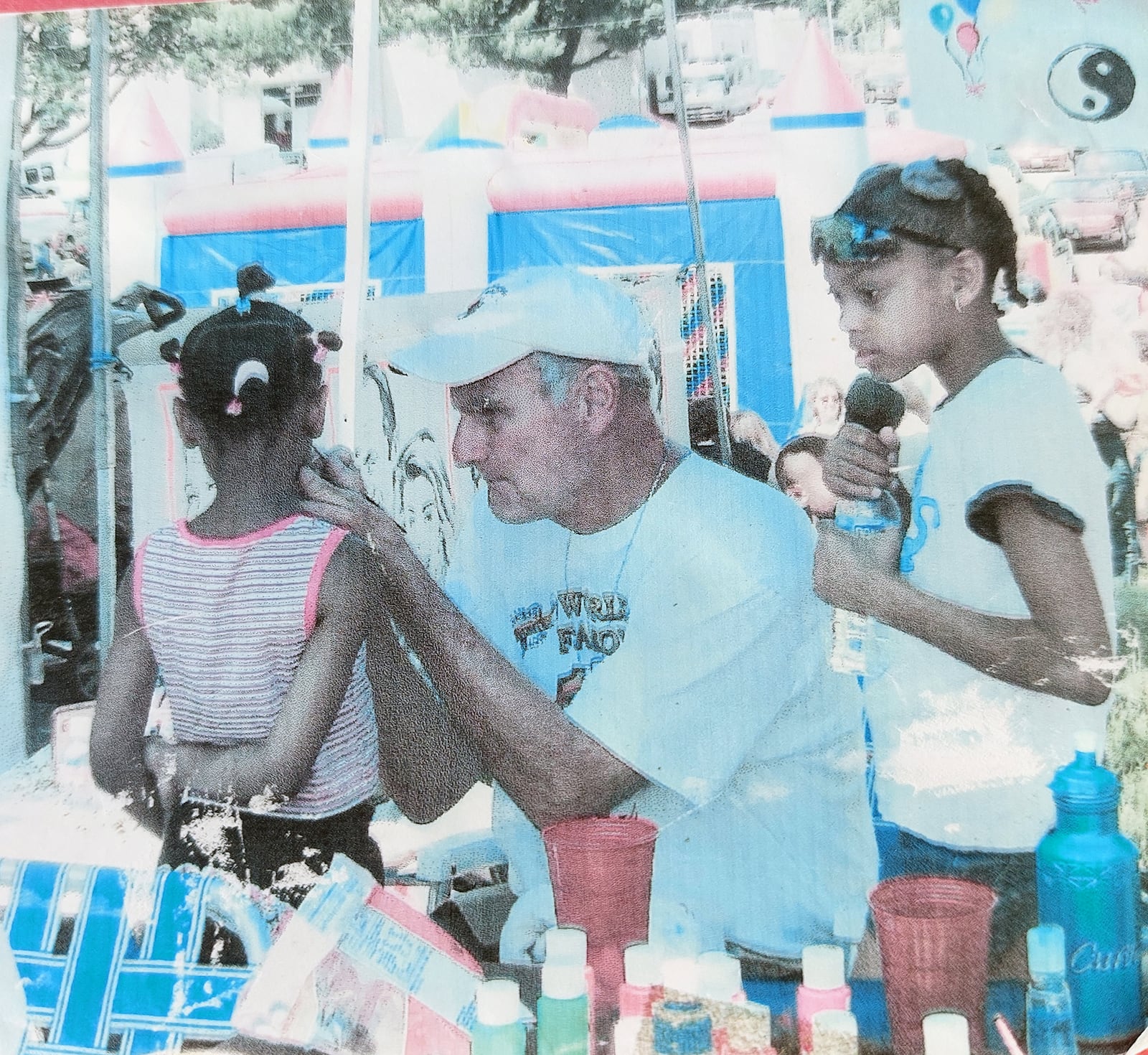 Doug Spraul (middle) paints faces at the Troy Strawberry Festival in the early 1990's.