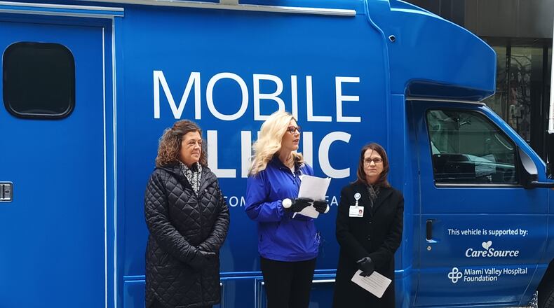 Dee Yocum, vice president of market operations for CareSource Ohio (left); Jenny Lewis, system vice president of philanthropy at Premier Health (middle); and Paula Thompson, president and CEO of Fidelity Health Care (right), unveil Premier Community Health's new mobile clinic in downtown Dayton on Friday, Jan. 20. Premier Community Health is a subsidiary of Fidelity Health Care, and the new mobile clinic was funded by CareSource through the Miami Valley Hospital Foundation. SAMANTHA WILDOW\STAFF