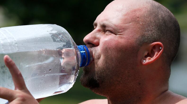 Chris Benfield drinks water on a hot day near The Shoppes at Valle Greene in Fairborn in this 2014 file photo. TY GREENLEES / STAFF