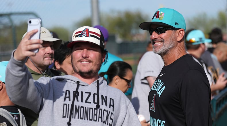 Arizona Diamondbacks manager Torey Lovullo smiles as he takes a selfie with a fan during spring training baseball Thursday, Feb. 12, 2026, in Scottsdale, Ariz. (AP Photo/Ross D. Franklin)